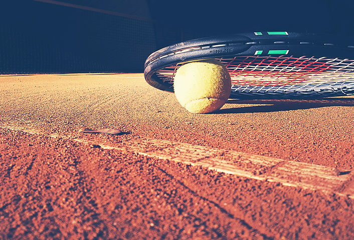 Tennis racket on a clay court. 