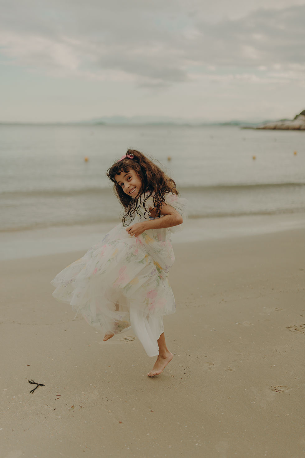 Ensaio infantil na praia da Figueira em Santa Catarina, criança brincando na areia em um dia de sol