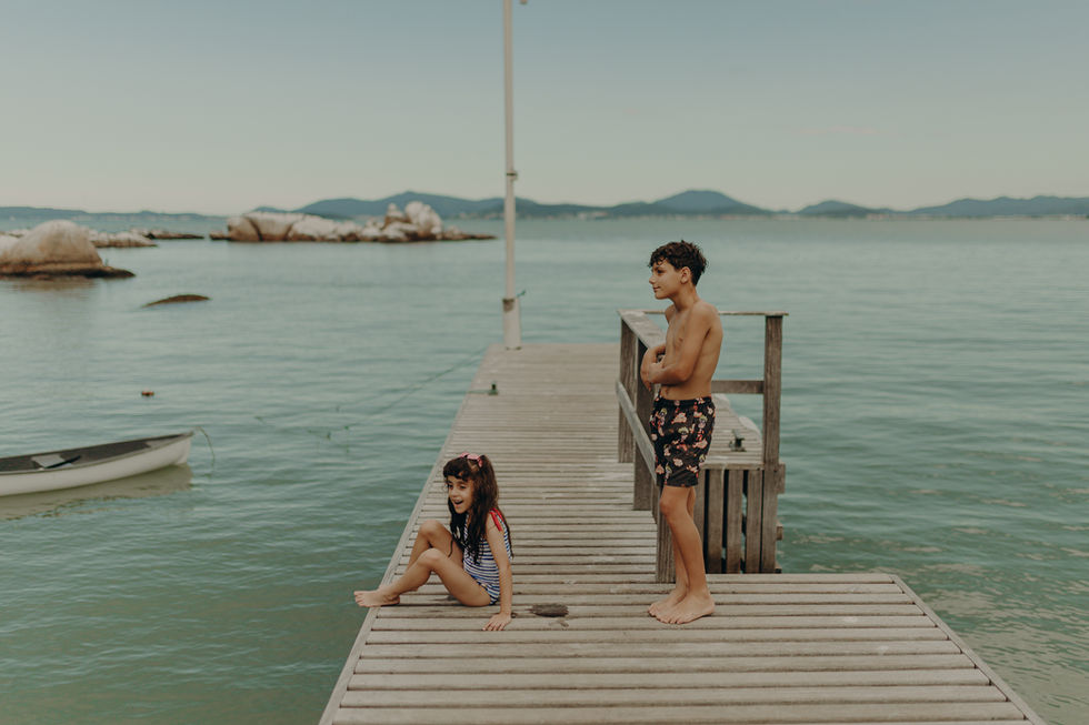 Ensaio infantil na praia da Figueira em Santa Catarina, criança brincando na areia em um dia de sol