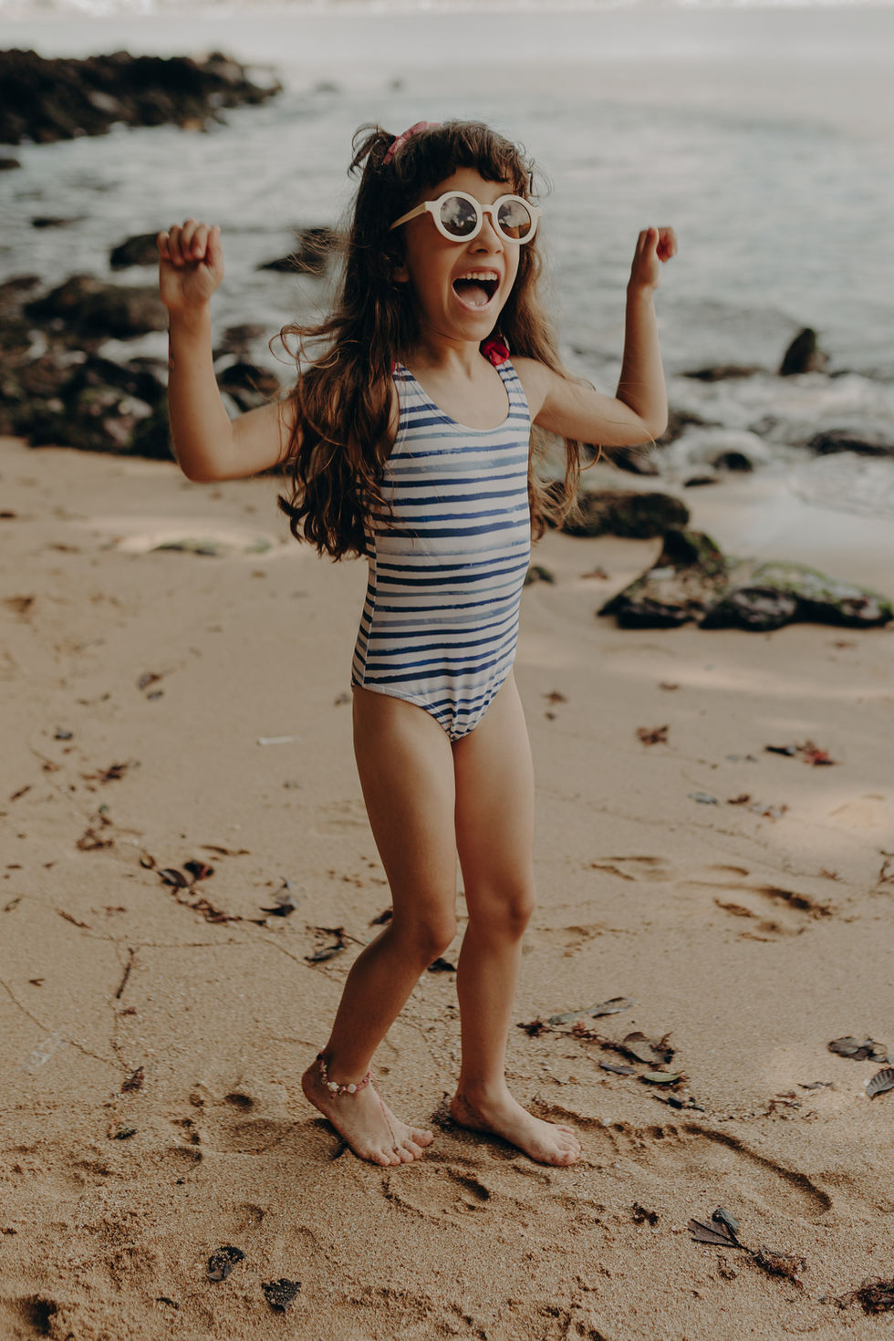 Ensaio infantil na praia da Figueira em Santa Catarina, criança brincando na areia em um dia de sol