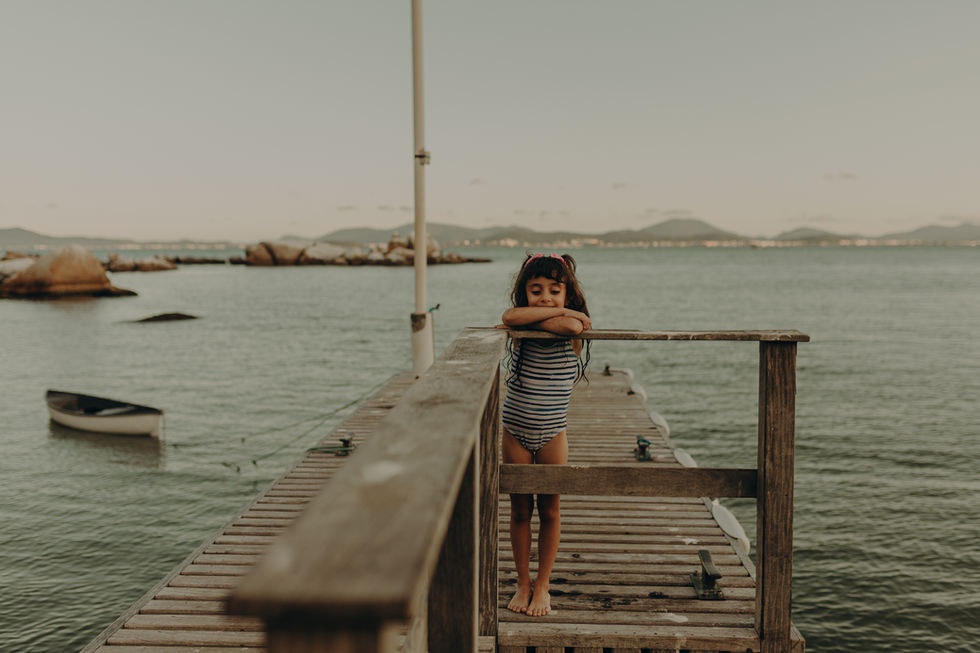 Ensaio infantil na praia da Figueira em Santa Catarina, criança brincando na areia em um dia de sol