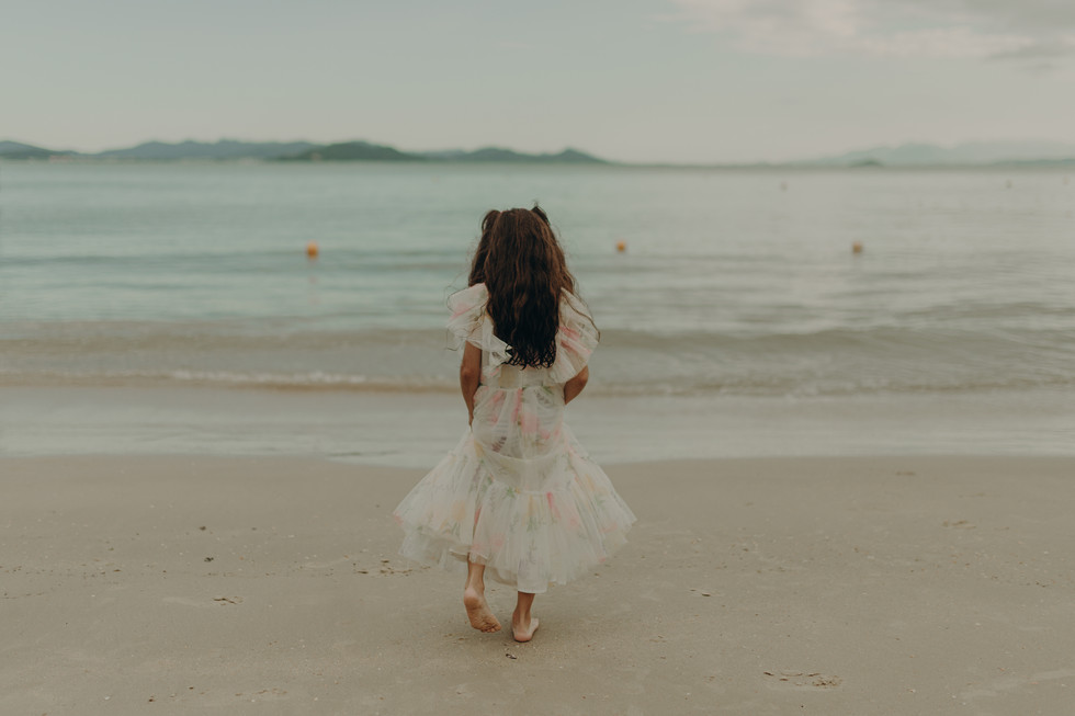Ensaio infantil na praia da Figueira em Santa Catarina, criança brincando na areia em um dia de sol