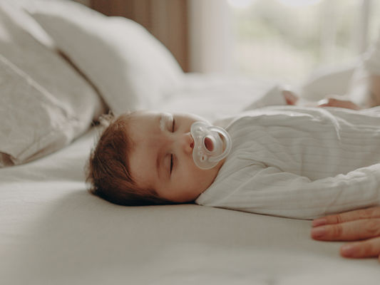 um bebê de 3 meses dormindo no ensaio fotográfico usando chupeta