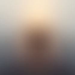 A person standing on a misty bridge with soft golden light ahead, arms open, surrendering to the unknown.