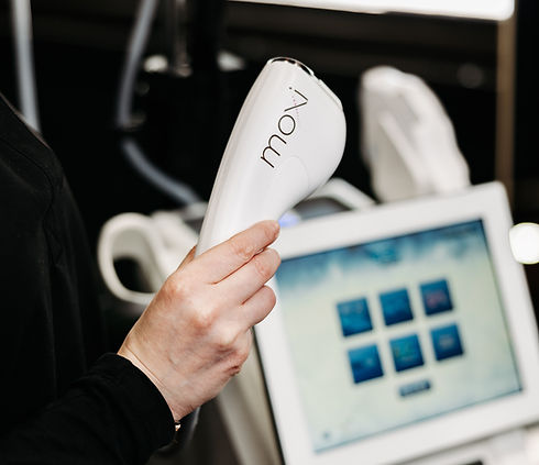 Person holding a white Moxi device before a treatment is provided