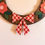 Thumbnail: Wooden wreath decorated with red flowers, green leaves, and plaid bow.