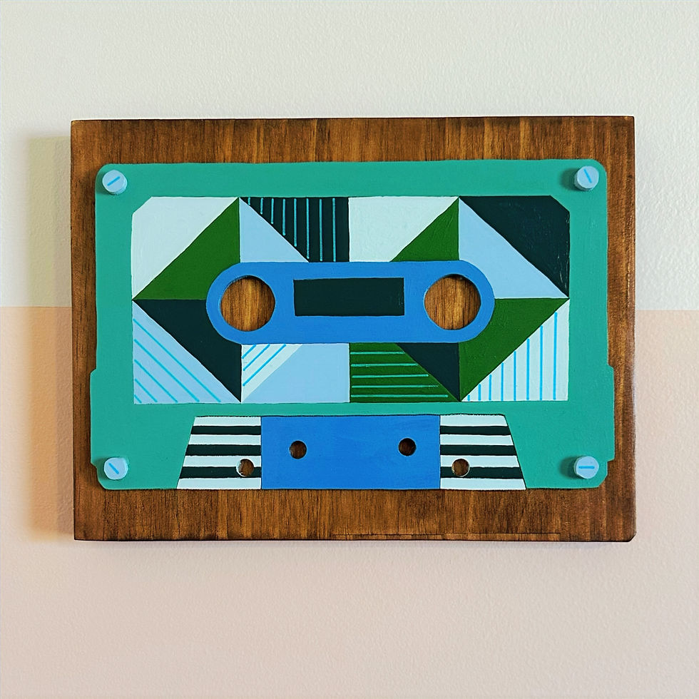 Decorative cassette tape art with geometric patterns on a wooden plaque.