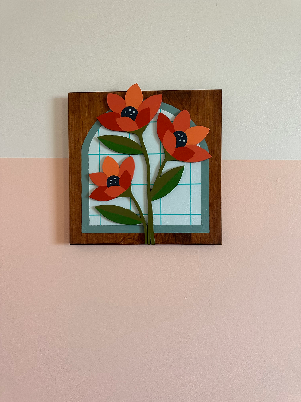 Thumbnail: Wooden framed art with three red-orange paper flowers over a blue window.