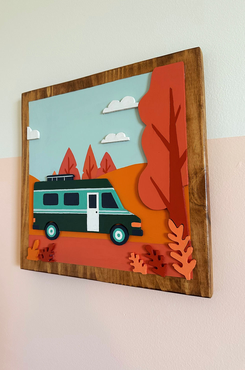 Thumbnail: Layered paper art features a teal camper van amidst orange hills, red trees.