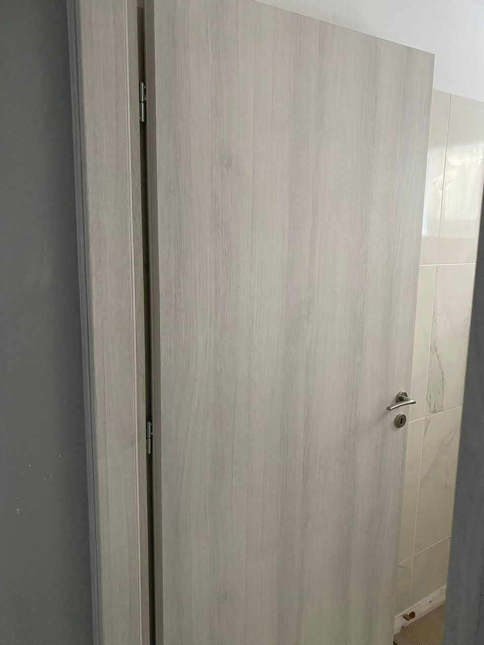Wooden door slightly ajar in a dimly lit room.