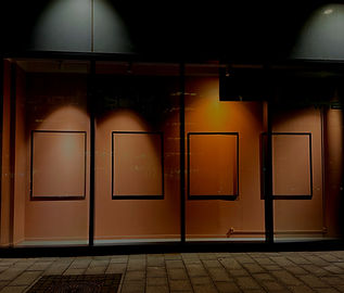 A storefront window at night displaying identical empty frames except for one, echoing Oscar Wilde's quote on authenticity