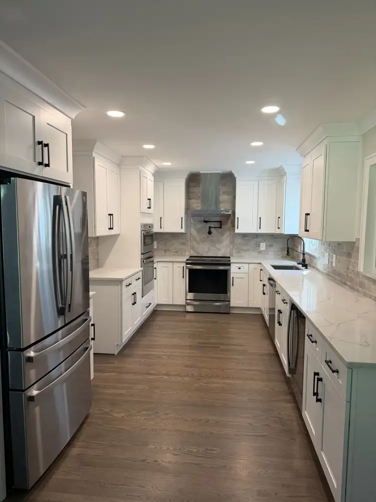 Kitchen remodel in Shaker Heights with white shaker cabinets, quartz countertops and herringbone tile accent