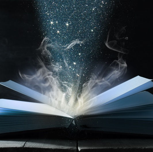 Open book with lights and stars rising from the middle of the pages