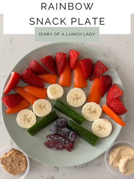 Rainbow snack plate with strawberries, peppers, bananas, cucumbers, frozen blueberries, and blackberry candy fish