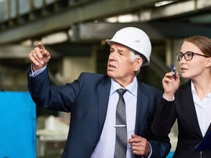Man in Hardhat with Woman on Factory Floor