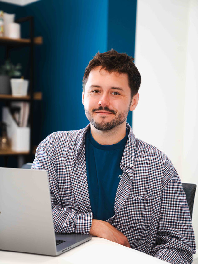 Ant Farmiloe is sitting at a desk during a design meeting with a client.