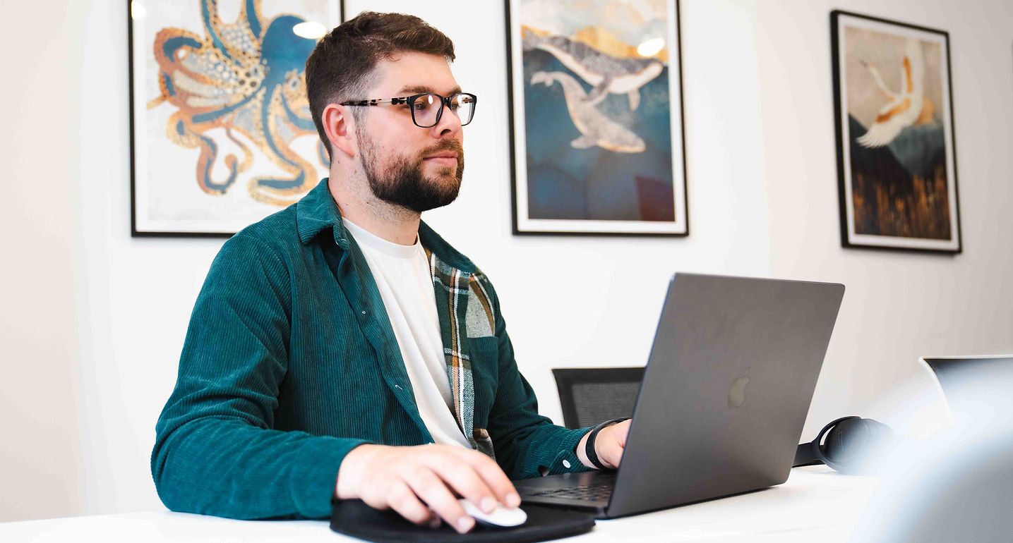 Dan Farmiloe sitting at his desk working on a video edit for a brand's social media.