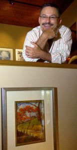 Ben Ortiz poses for a photo with the piece of art he purchased when he was 13 years old. The painting by Don Miguel Pou, bottom, was sold to Ortiz for 75 cents in a tag sale. Photo: Courtesy Connecticut Post