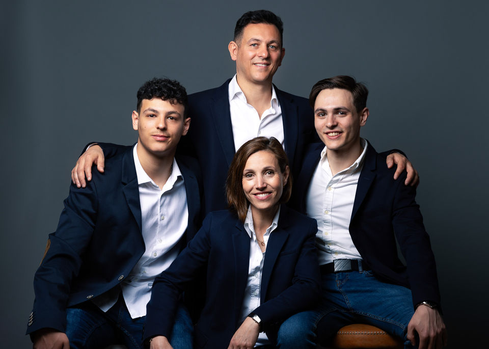 Family portrait: parents and two sons in suits