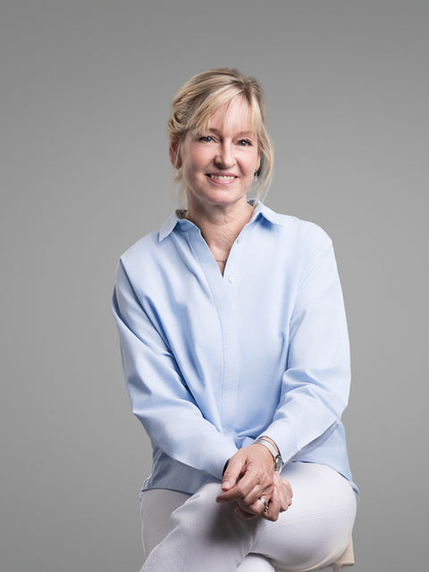 Blonde woman in blue shirt smiling