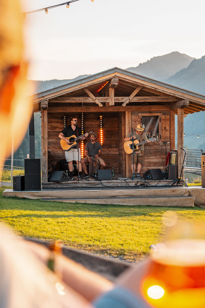 Musiker spielen bei Sonnenuntergang am Berg