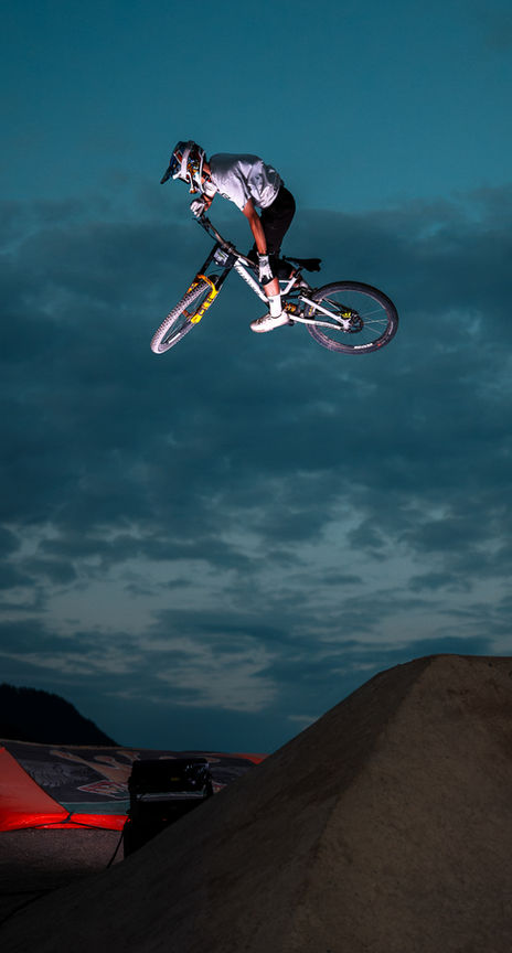 Mountain biker jumps over a ramp at night