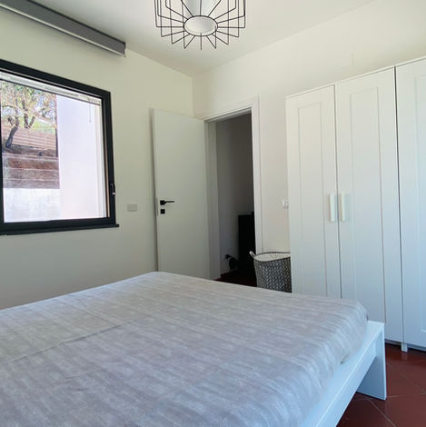 Spacious master bedroom with wardrobe, elegant furnishings and relaxing atmosphere at Tenute Lomasi