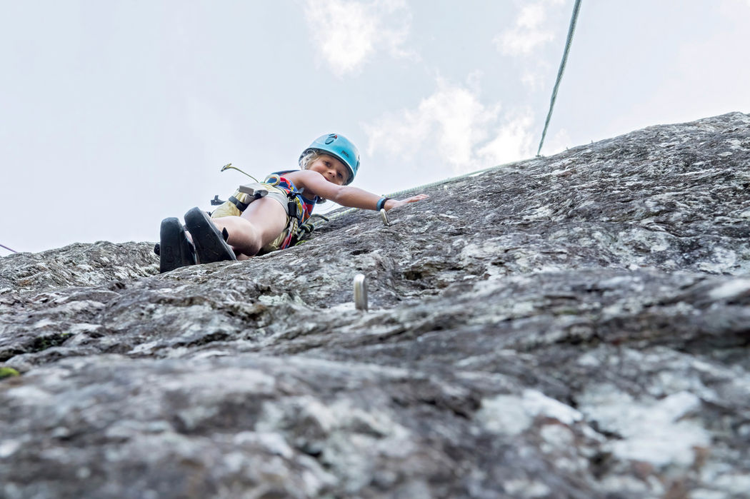 Ein Kind mit blauem Helm das klettert