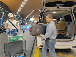 吉隆坡 KLIA / KLIA2 机场接送专车服务,司机把全部行李排好放在手推车,车在 KLIA Departure Lane 的路旁画面