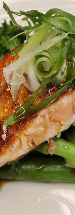  A serving plate with tender asparagus and a slice of meat arranged together.