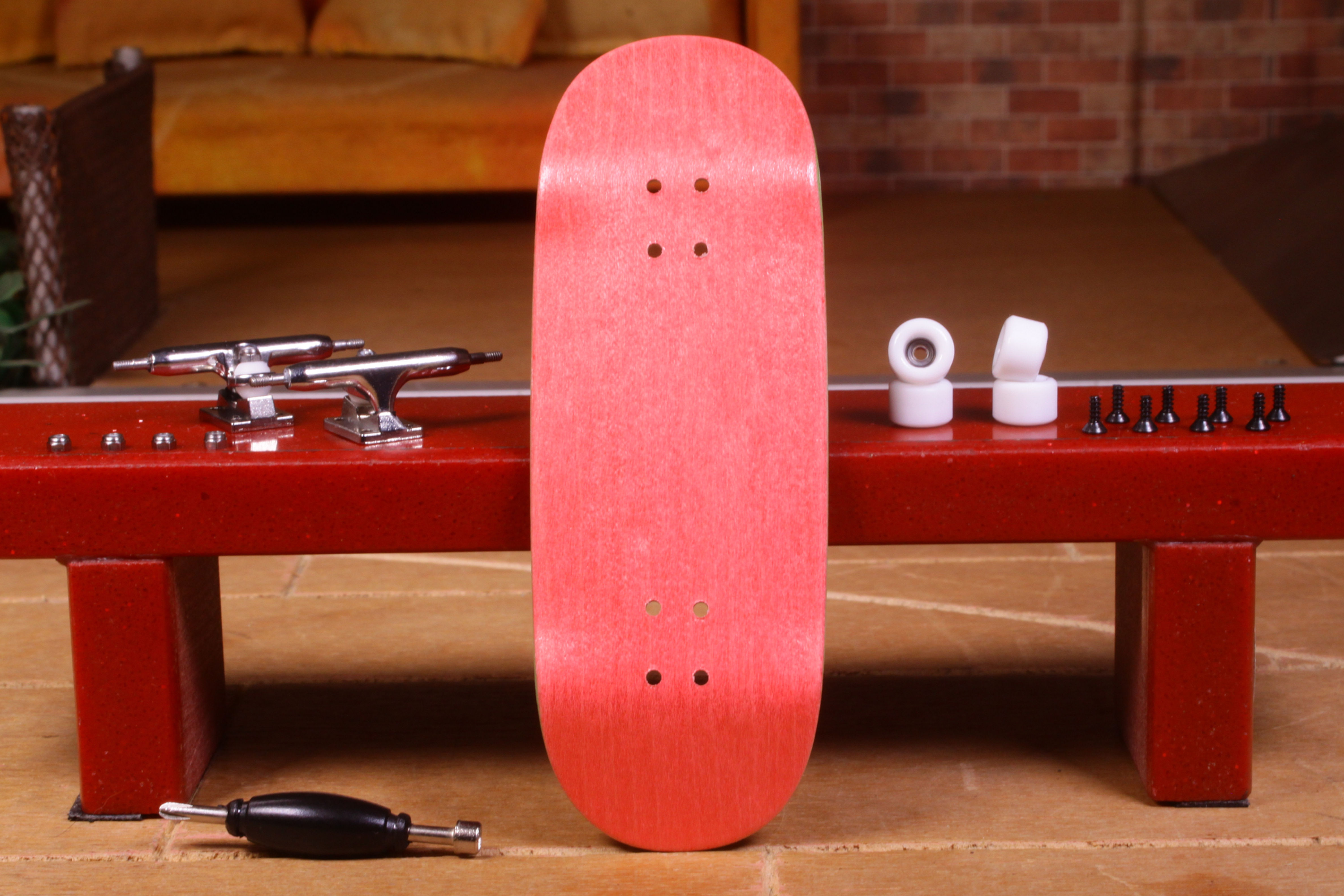 Pink fingerboard, Flatface Decks G16 "Purple" 33.6mm, on a red surface with tools.