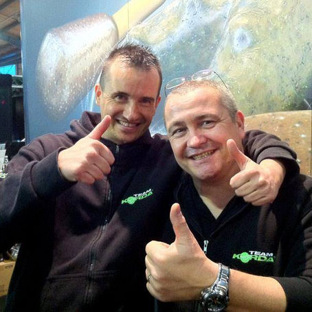 Stand de salon de pêche dédié à la carpe avec affiches de magazines et matériel exposé lors d’un événement pêche en France