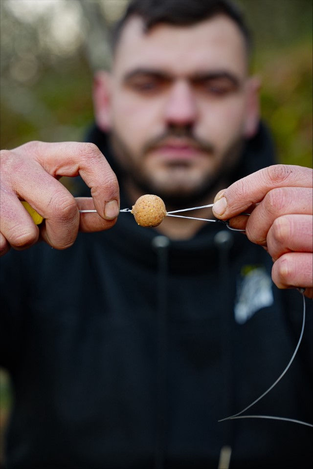 11 - Passez un grand morceau de Baits floss dans la partie libre du micro ring swivel. Doublez-le afin de bien combler le trou de l’aiguille à bouillette.