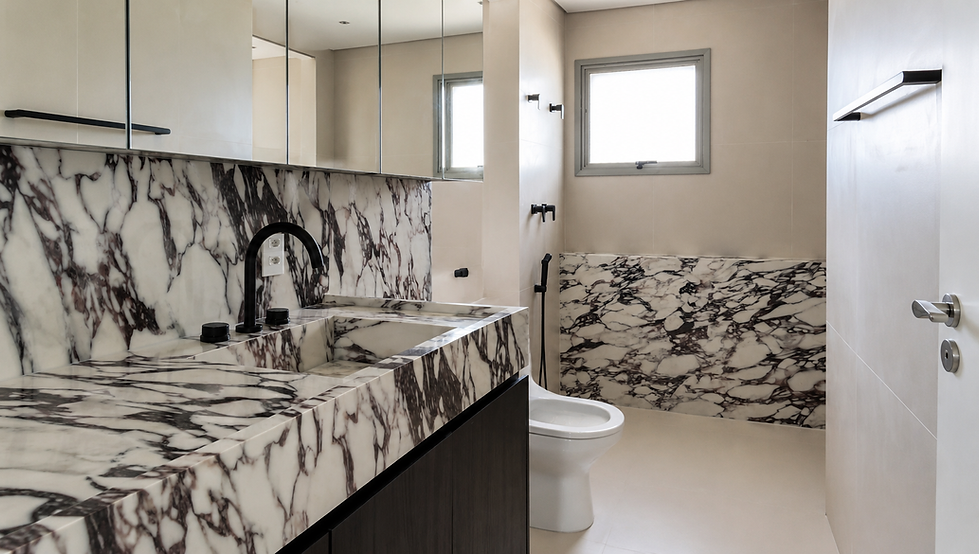 Banheiro do Apartamento MT01 em Perdizes, São Paulo, projetado pela GUZLIVE, com bancada e cuba esculpidas em mármore branco de veios escuros, armário inferior em madeira escura, metais pretos, espelho amplo e revestimentos claros.