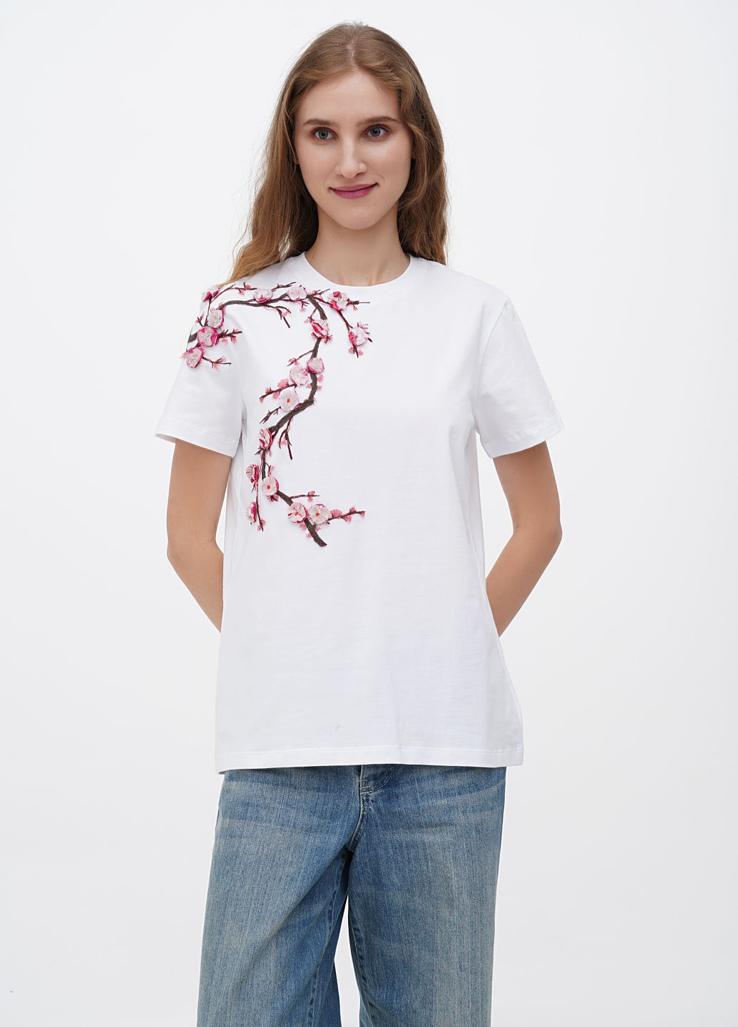 Female model wearing a designer t-shirt with a vibrant graphic.