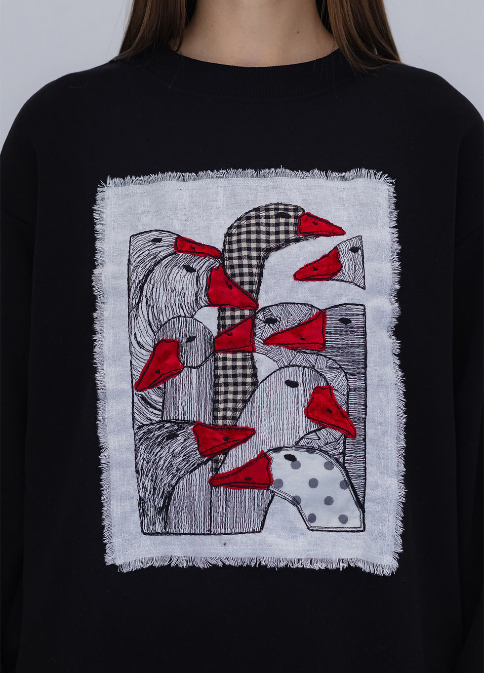 Thumbnail: Female model wearing a designer sweatshirt with a vibrant graphic.