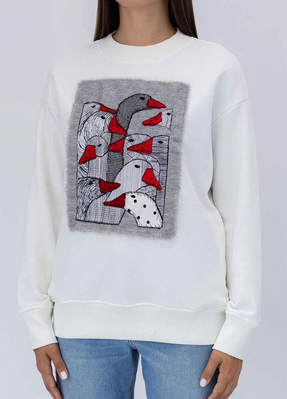 Thumbnail: Female model wearing a designer sweatshirt with a vibrant graphic.