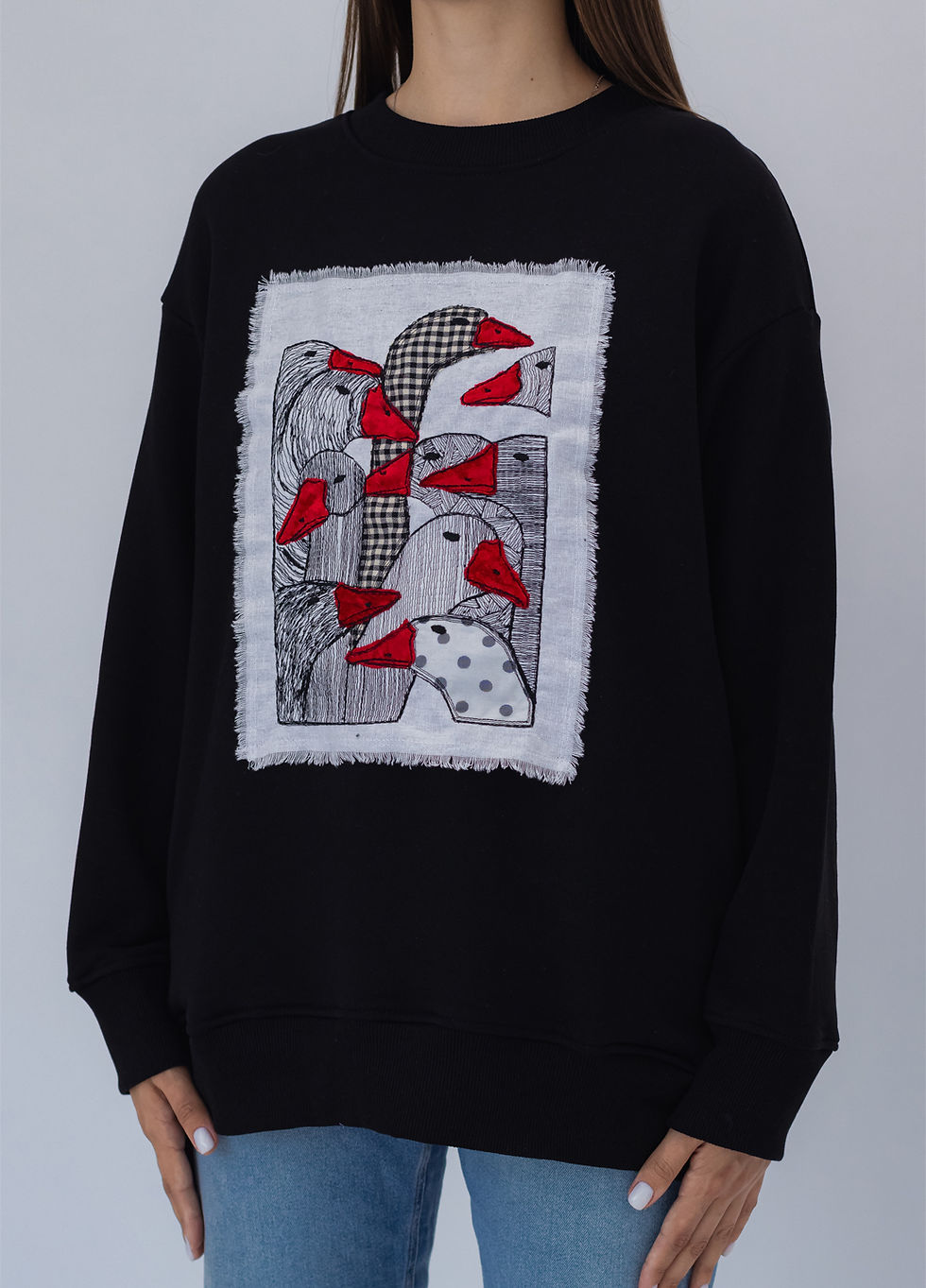 Thumbnail: Female model wearing a designer sweatshirt with a vibrant graphic.