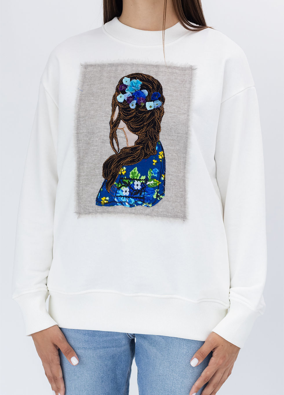 Прев'ю: Female model wearing a designer sweatshirt with a vibrant graphic.