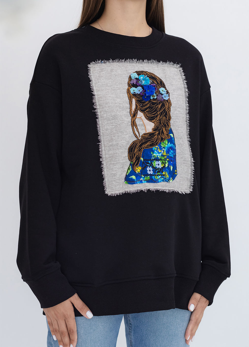 Thumbnail: Female model wearing a designer sweatshirt with a vibrant graphic