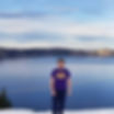 Matthew Sazma wearing a Vikings shirt on the edge of Crater Lake.