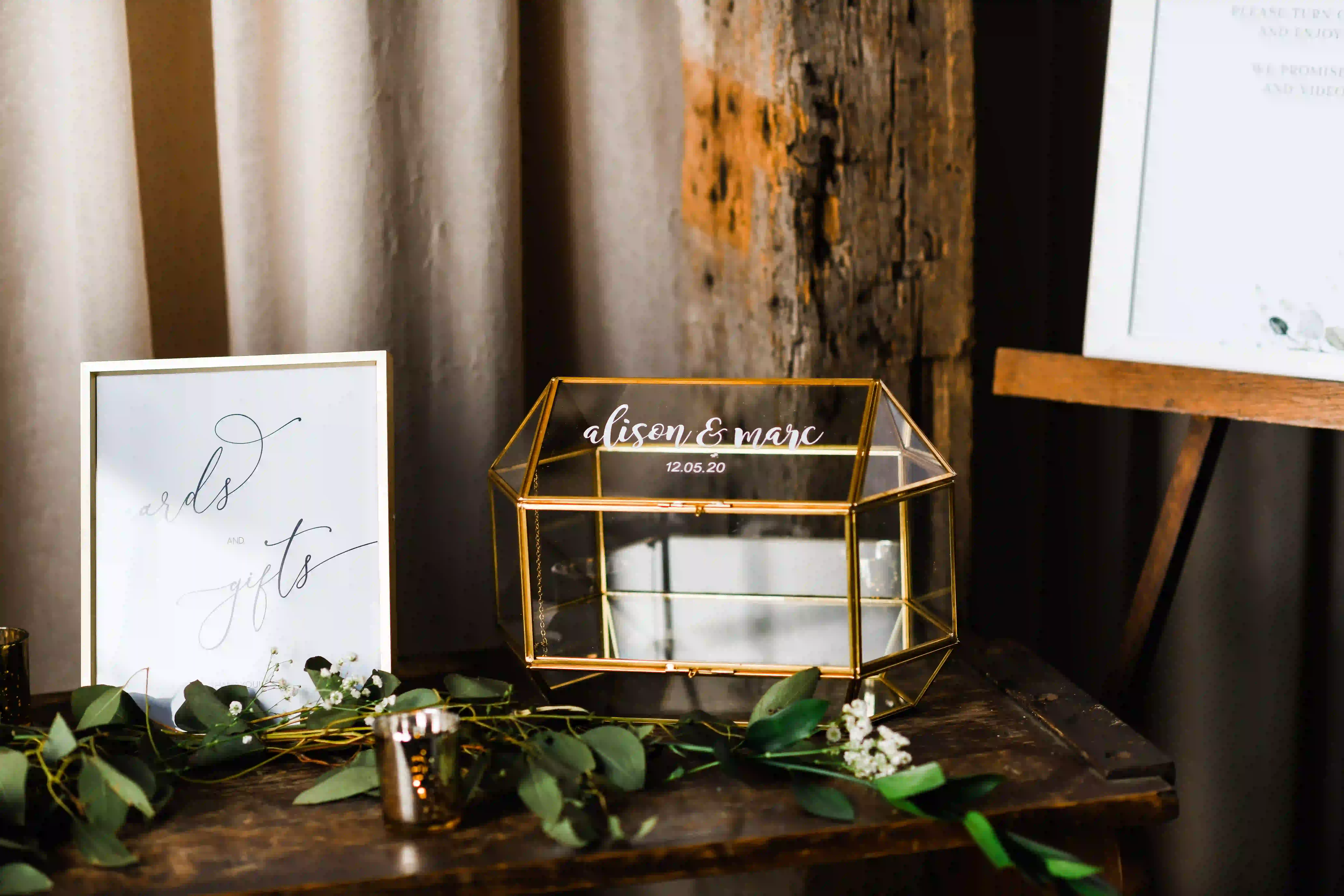 Glass and brass geometric wedding card box on a wooden welcome table at The Barn at Silverstone, a luxury wedding venue in Lancaster, PA.