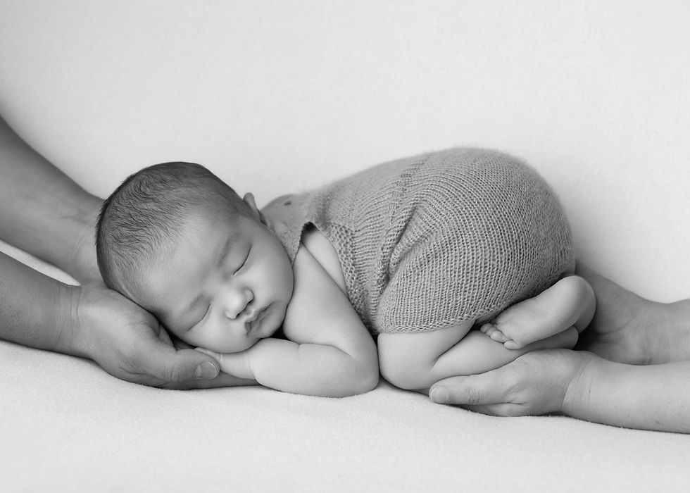 Black and white newborn portrait, baby cradled in parents' hands at Kirsten Naomi Photography, Christchurch