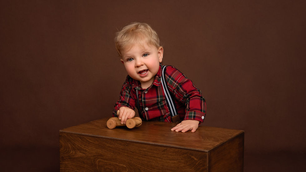Smiling baby boy playing with a wooden toy car, photograph by Christchurch Baby Photographer Kirsten Naomi Photography