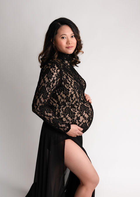 Maternity photograph of a pregnant mum-to-be showing her perfect pregnancy bump in a fitted black lace and chiffon dress by Christchurch maternity photographer Kirsten Naomi Photography
