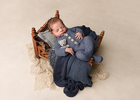 Newborn baby boy sleeping in a tiny bed wearing a vintage knit romper by Christchurch Newborn Photographer Kirsten Naomi Photography