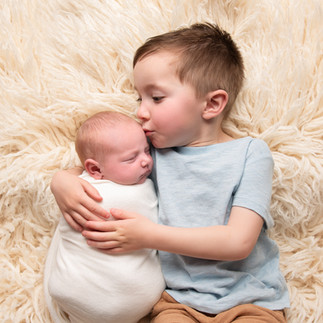 Toddler kissing his newborn baby sister, photo by Christchurch Newborn Photographer Kirsten Naomi Photography