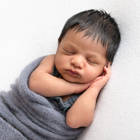 Photograph of a newborn baby boy sleeping with his hands under his face by Christchurch newborn, baby & family photographer Kirsten Naomi Photography
