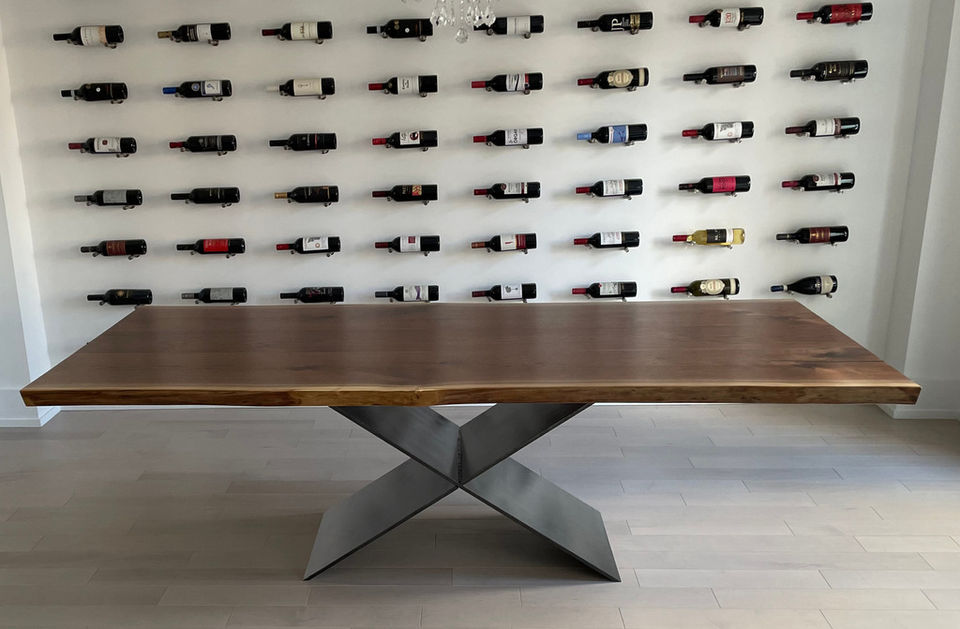 Cherrywood Studio black walnut dining table with a plate steel base, handcrafted in Ontario and displayed in a modern Toronto home with a wall-mounted wine display.