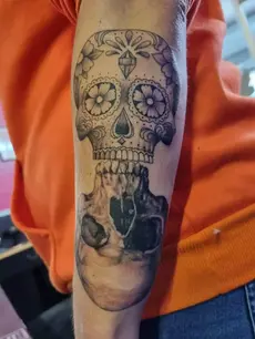 Tatouage d'une double tête de mort sur l'avant bras, l'une très réaliste, ombragé, l'autre dans le style des têtes de morts Mexicaine. Un tatouage proposé par L'ink Tattoo Quissac, tatoueur dans le Gard (30)